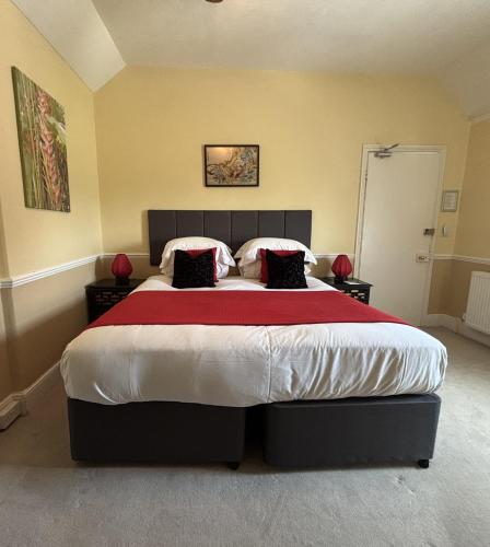 ein Schlafzimmer mit einem großen Bett und einer roten Decke in der Unterkunft Fernhill Hotel in Lyme Regis