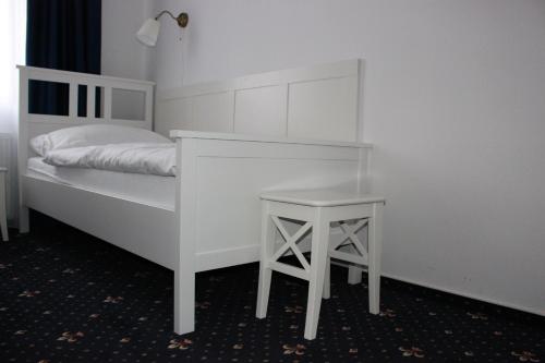 a bedroom with a white bed and a table at Hotel Amadeus in České Budějovice