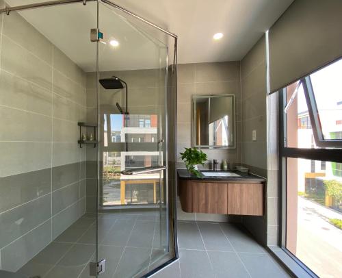 a bathroom with a glass shower and a sink at MeySunset Hotel Phu Quoc in Phú Quốc