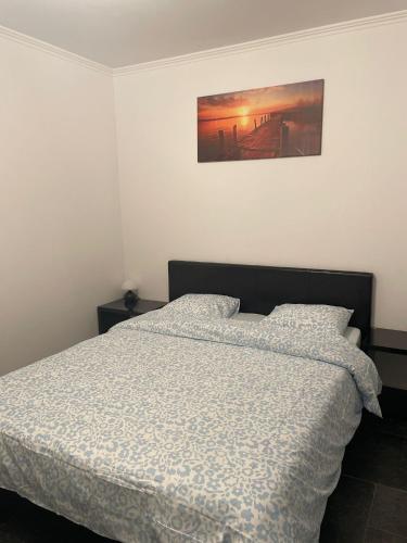 a bedroom with a bed and a painting on the wall at Coquille in Nieuwpoort