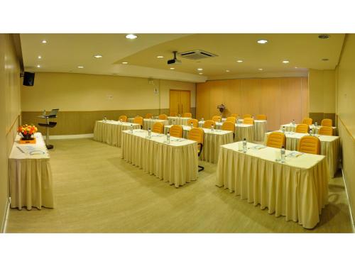 a room with rows of tables and chairs at Hotel Aliança Express in Rio do Sul