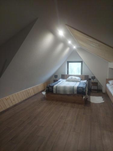a attic bedroom with a bed and a window at Pod skosem in Witów