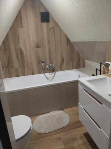 a bathroom with a white toilet and a sink at Pod skosem in Witów