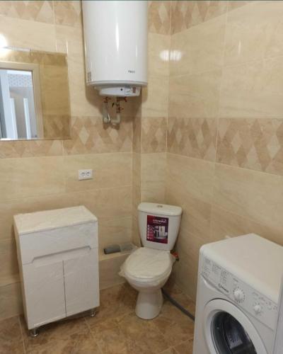 a bathroom with a toilet and a washing machine at ЖК Хмельницький in Dnipro