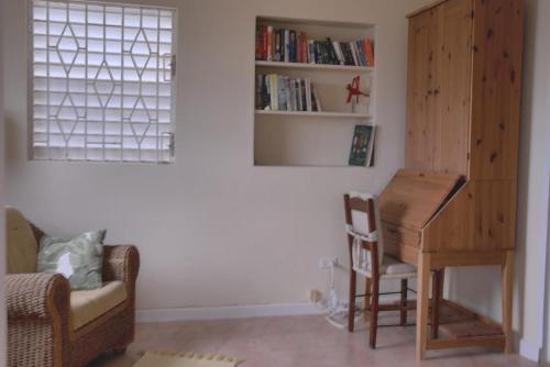 a living room with a piano and a chair at Mermaid Apartments in Saint Philip