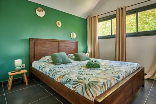 a bedroom with a large bed with green walls at Le Clos des Remparts - 8 pers - Cascades & Nature in La Plaine des Palmistes
