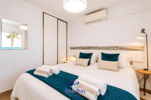 a bedroom with a large bed with towels on it at Shore Thing Playa in La Herradura