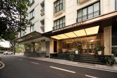 a store front of a building on a street at Luxeden Classic Hotel in Hanoi