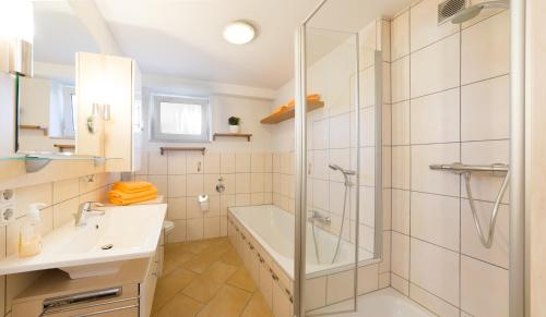 een badkamer met een douche, een bad en een wastafel bij Pension & Appartments Landhaus Bettina Fulda in Fulda