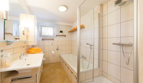 ein Badezimmer mit einer Dusche, einer Badewanne und einem Waschbecken in der Unterkunft Pension & Appartments Landhaus Bettina Fulda in Fulda