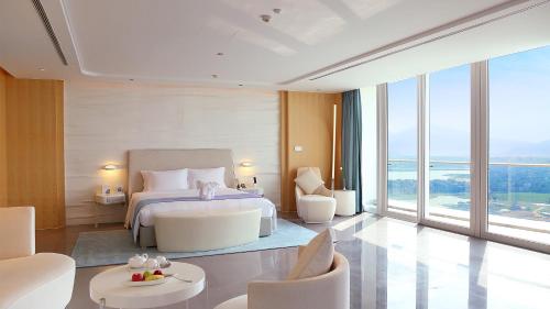 a hotel room with a bed and a large window at The Mangrove Sanya in Sanya