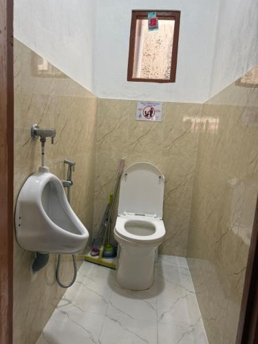 a bathroom with a toilet and a urinal and a sink at Hotel River View in Syābru Bensi