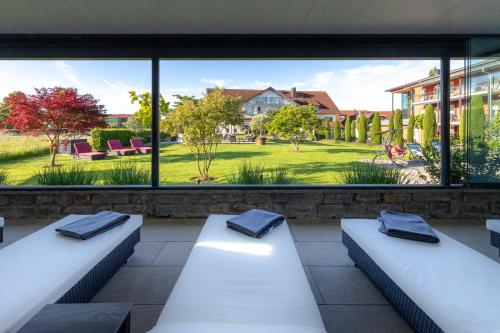 two white benches in front of a large window at Hotel Gierer in Wasserburg