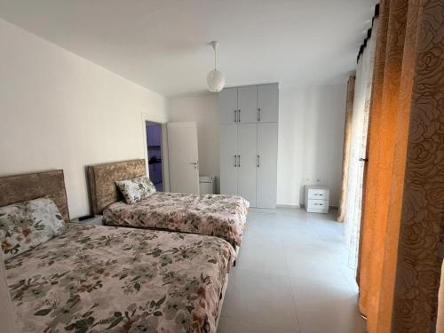 a bedroom with two beds in a room at Luxurious seaside apartment in Sakës
