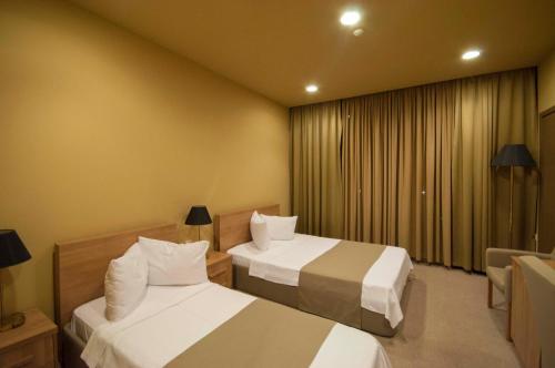 a hotel room with two beds and a window at Hotel Anaklia in Zugdidi
