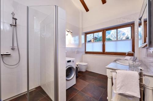 y baño con ducha y lavadora. en Ferienwohnung Alpspitzblick, en Garmisch-Partenkirchen