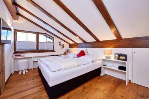 - une chambre mansardée avec un grand lit dans l'établissement Ferienwohnung Alpspitzblick, à Garmisch-Partenkirchen