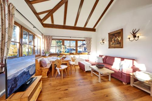 sala de estar con sofá y TV en Ferienwohnung Alpspitzblick, en Garmisch-Partenkirchen