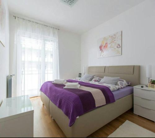 sypialnia z dużym łóżkiem i fioletowym kocem w obiekcie Apartment Ali w Zagrzebiu