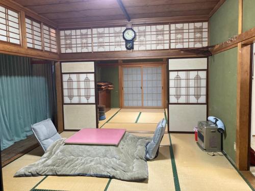 a room with a table and chairs and a clock at 天水島ヒルズ in Tokamachi