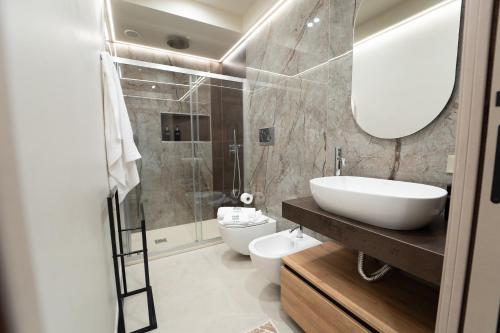 a bathroom with a sink and a toilet and a mirror at HERMES Luxury Home in Agrigento