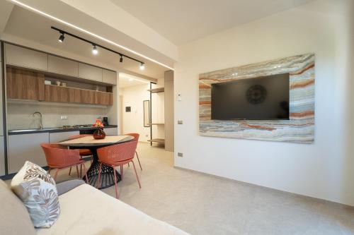a living room and kitchen with a tv on the wall at HERMES Luxury Home in Agrigento