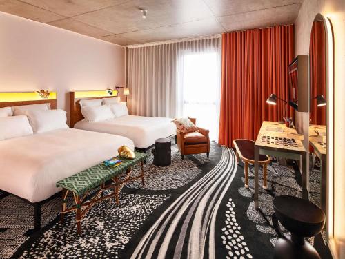 a hotel room with two beds and a desk at Mama Shelter Lille in Lille