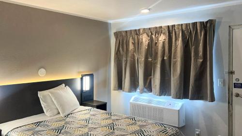 a bedroom with a bed and a window with at Studio 6 Elko, NV in Elko