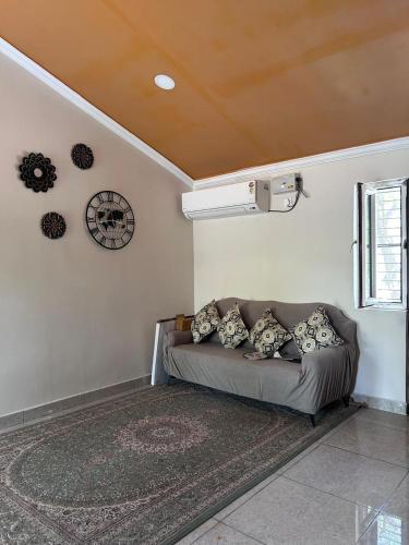a living room with a couch and a clock on the wall at Nadaa Organic Farms in Khammam