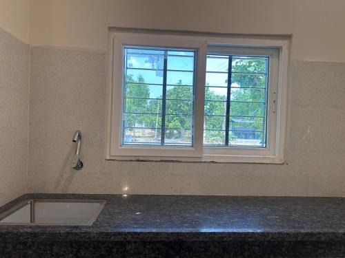 a kitchen with a sink and a window at Nadaa Organic Farms in Khammam