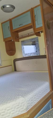 an empty bed in an rv with aoir at Peaceful Private Haven in Frongoch