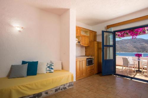 a room with a bed and a kitchen with a balcony at ILIDI Rock in Livadia