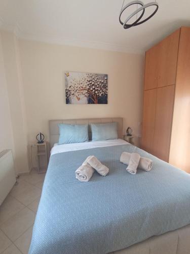 a bedroom with a blue bed with towels on it at BlackGeorge Apartment Mountain View in Ioannina