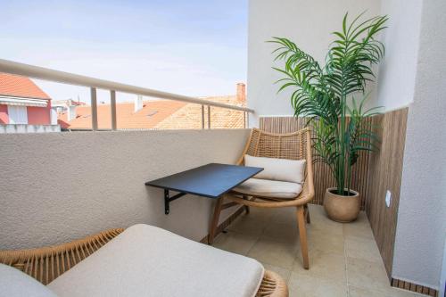 a small table and chair on a balcony with a plant at Luxury Rooms by Iva in Zadar