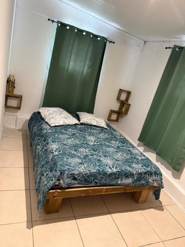 a bed in a room with green curtains at Kay Yvette in Saint-Pierre