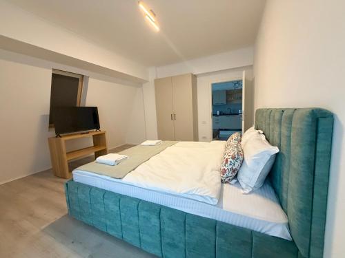 a large bed with a blue headboard in a room at DOCA Apartments 10 in Otopeni