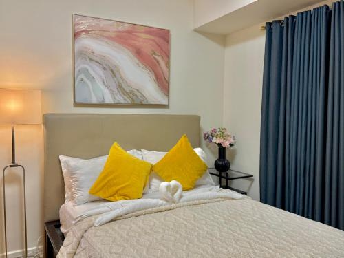 a bedroom with a bed with yellow pillows at Corner Studio in Ermita Manila near US Embassy and SLMEC in Manila