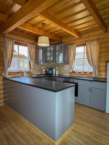 a kitchen with a large island in the middle at Tatralake Log Cabin - Drevenica pri Mare in Liptovský Mikuláš