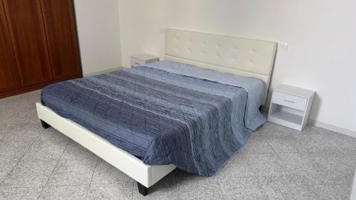 a bedroom with a bed with a blue comforter at Casa Narciso, semi-detached cottage in Marina di Massa
