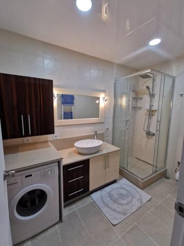 a bathroom with a sink and a washing machine at Воскресенская 12 Евро in Dnipro