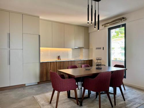 a kitchen with a dining room table and chairs at Beachfront Rafailovici - Budva in Rafailovici