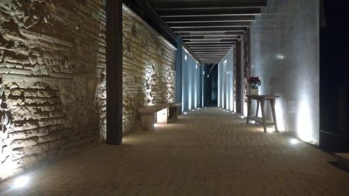 a hallway with benches and a brick wall at El Callejón Hotel Boutique in Oaxaca City