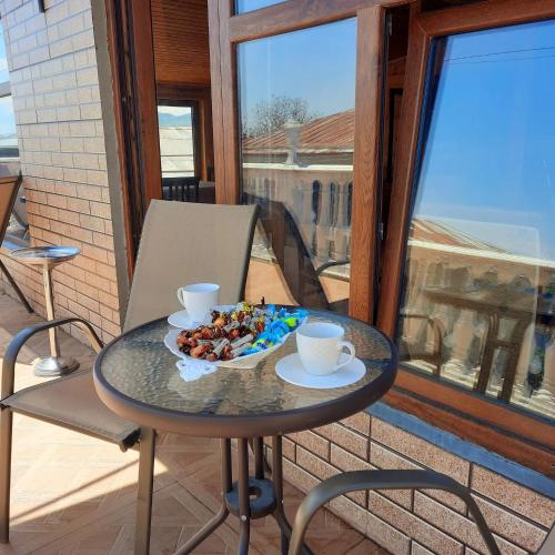 a table with a plate of food on a balcony at Guesthouse IMEDI in Velistsʼikhe