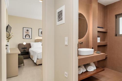 a bathroom with a sink and a bed in a room at Palm View Suites in Kourouta