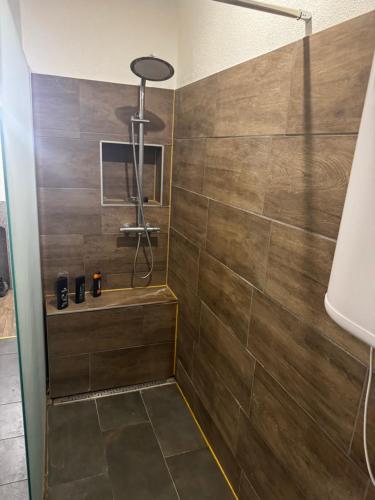 a bathroom with a shower with wooden tiles at Monteur- & Gästewohnung Coswig in Coswig