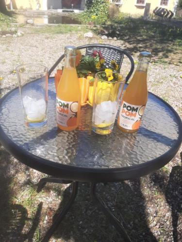 a table with three bottles and glasses on it at Strandhgarden B&B Cozy Room near Malmo in Oxie