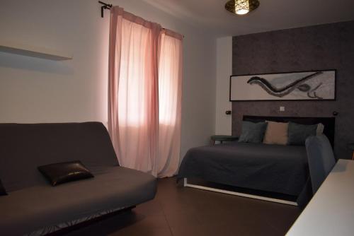 a bedroom with a bed and a couch and a window at Wellness Villa Istriana in Umag