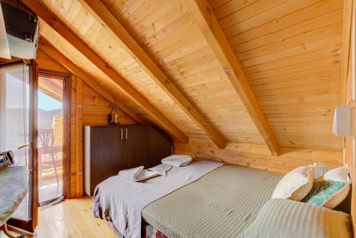 a bedroom with two beds in a wooden room at Seaview Chalet in Herceg-Novi