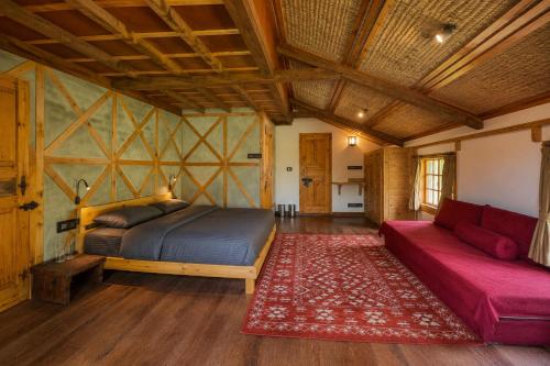 a bedroom with a bed and a couch in a room at Shepherd Barn Pahalgam in Pahalgām