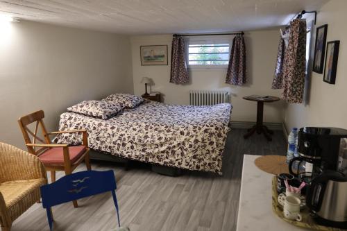 a bedroom with a bed and a chair at Accueil Porte-Dunoise in Orléans